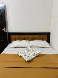 a bed with a white towel on top of it at Stay Kattil Varkala in Varkala
