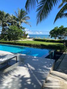 a swimming pool with a view of the ocean at Beachfront in Ban Lum Fuang