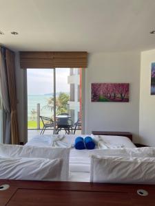 a bedroom with two beds and a view of the ocean at Beachfront in Ban Lum Fuang +7 photos
