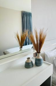 two vases sitting on a table in front of a mirror at Modern Condo in Nimman P605 by Pimolplace in Chiang Mai