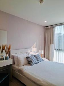 a bedroom with a large white bed with a window at Modern Condo in Nimman P605 by Pimolplace in Chiang Mai +21 photos