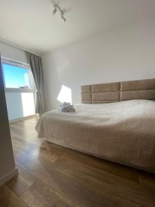 a bedroom with a bed and a large window at Go2Nati apartament in Gdańsk