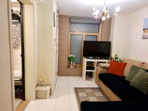 a living room with a couch and a television at Residentie Ruytingen in Ostend