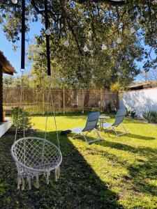 two chairs and a swing in a yard at Casita Louisa in Chiclana de la Frontera