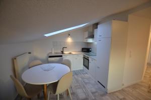 a kitchen with a white table and chairs at FeWo Landkirchen 2 in Fehmarn