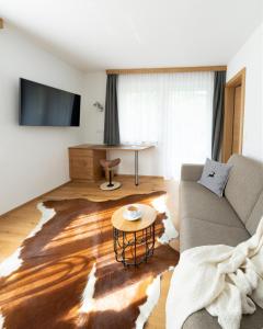 Televízia a/alebo spoločenská miestnosť v ubytovaní Apartments Hohenberger Mallnitz - Mein Platz in den Bergen!