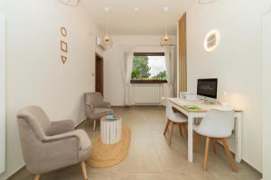 a living room with a desk and chairs and a computer at Villa Mamma Grazia Rooms in San Vito dei Normanni