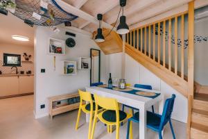 a dining room with a white table and yellow chairs at CsakAkali in Balatonakali