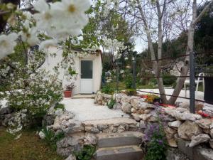 a garden with white flowers and a white door at Studio Biokovo smaller object 22 m2 in Makarska