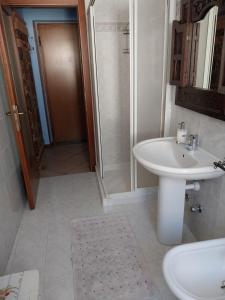 a white bathroom with a sink and a shower at Appartamento centro storico in Riva del Garda +25 photos