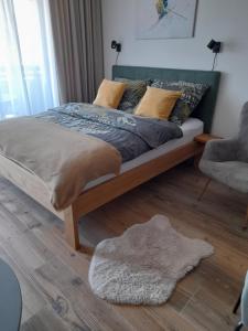 a bedroom with a bed and a rug on the floor at Modern Alpine Apartment Corso Harrachov in Harrachov