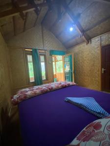 a bedroom with a large purple bed in a room at Gunung baru homestay in Senaru