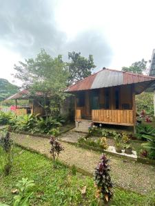 a house with a thatched roof in a garden at Gunung baru homestay in Senaru