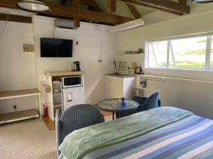 a living room with a table and a kitchen at Superb Studio Retreat with Private Secluded Spa, plus Pool & BBQ access in Whanganui