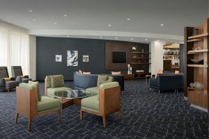een lobby met banken en stoelen en een televisie bij Courtyard by Marriott Salisbury in Salisbury