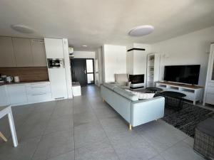a living room with a couch and a kitchen at Lake House 513 in Šajdíkove Humence