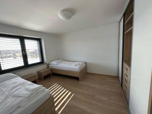 a bedroom with two beds and a window at Lake House 513 in Šajdíkove Humence