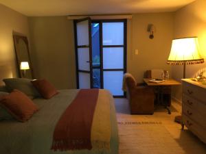 a bedroom with a bed and a desk and a window at NeNe in Dilbeek