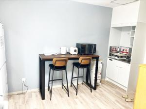 una piccola cucina con un tavolo con due sgabelli di Villa Hayabusa ad Osaka