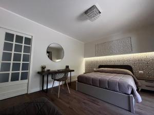 a bedroom with a bed and a table and a mirror at Gira e Firria in Palermo