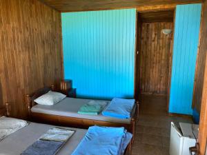 two beds in a room with blue walls at Дървени къщички - Лион in Sinemorets