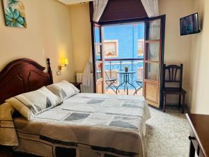 a bedroom with a bed and a view of a balcony at Hotel las Palmeras Suite in Celorio