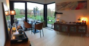 a living room with a table and a dining room at La Pacha, chambre d'hôtes in Spa