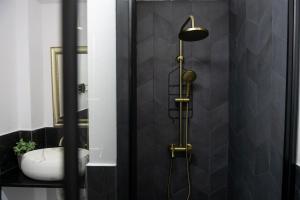y baño con ducha y azulejos negros. en Celine Apartments, en Piatra Neamţ 37 fotos más