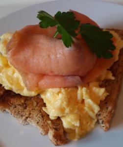 uma sanduíche de pequeno-almoço com presunto e ovos num prato em Ogilvy House em Cromer