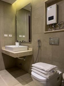 a bathroom with a sink and a toilet and a mirror at شقة فندقية الشيخ زايد - Zayed Suites F in Sheikh Zayed +38 photos