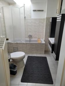 a bathroom with a toilet and a tub and a sink at FeWo Landkirchen 2 in Fehmarn +10 photos