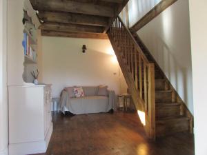 sala de estar con escalera y sofá en Les Puvinieres, en Breuil-Barret
