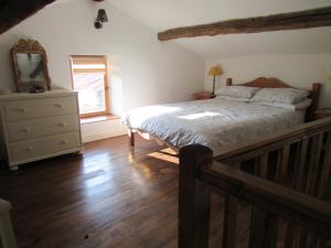 a bedroom with a bed and a dresser and a window at Les Puvinieres in Breuil-Barret