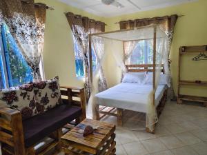 蒙巴萨Mount Zion Guest House, Mtwapa Mtomondoni的带床、沙发和窗户的卧室