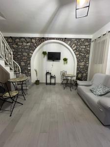 ein Wohnzimmer mit Couch, Tischen und Fernseher in der Unterkunft Dimora Dante in Amantea