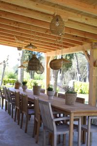 a long wooden table with chairs and potted plants at Can Jan Vives in Vidreres