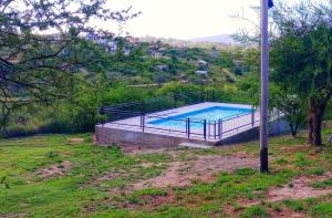 a swimming pool with a metal fence around it at Nuestras raíces 1 in Villa Carlos Paz