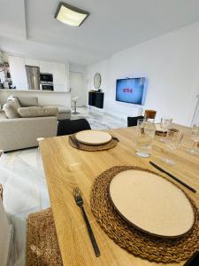 a wooden table with two plates on it in a living room at Duplex Penthouse with Seaview. in Benalmádena