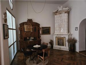 a dining room with a table and a fireplace at ANNO 1800 in Bistriţa