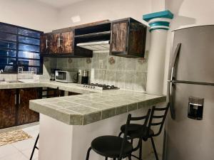 a kitchen with a refrigerator and two chairs in it at Casa Quintana in Bacalar