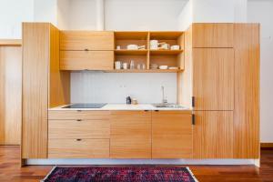 ポルトにあるHey Apartments Cの木製のキャビネットとシンクを備えたキッチン +9枚の写真