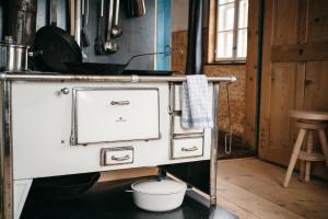 a kitchen with an old stove in a room at Floras Haus Hostel in Schattwald