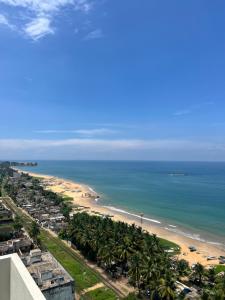 a view of a beach with palm trees and the ocean at Pearly Ocean View Suite in Dehiwala