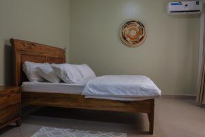 un lit avec des draps blancs et des oreillers dans une chambre dans l'établissement Ritah Rentals, à Kampala