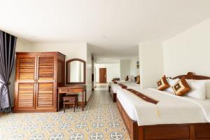 a hotel room with a row of beds and a desk at Sunflower Angkor Boutique Hotel in Siem Reap