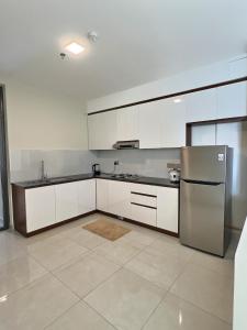 a kitchen with white cabinets and a stainless steel refrigerator at Pearly Ocean View Suite in Dehiwala