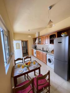 a kitchen with a table and chairs and a refrigerator at Elia Old Mansion in Malona Village