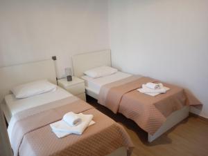 two beds in a room with towels on them at Zoe's Apartment in Pídima Kyrás