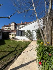 a white house with a yard with flowers at Maison proche centre-ville in Dijon