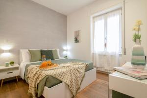 a bedroom with a bed with a table and a window at CASA ANTO - Charming apartment 50 meters from the beach in Alghero